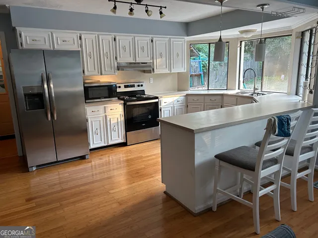 a kitchen with granite countertop a sink appliances and cabinets