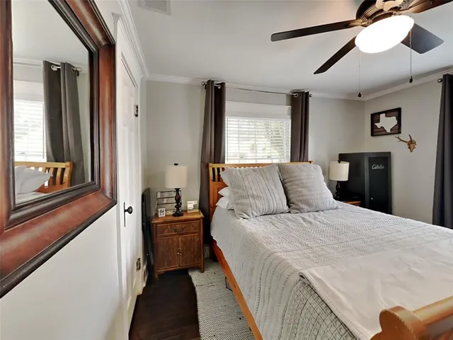 a bedroom with a bed and a large mirror with a hardwood