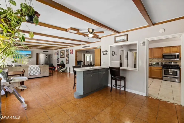 a living room with furniture and a dining table with kitchen view