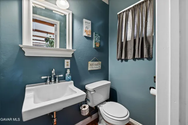 a bathroom with a toilet a sink and mirror