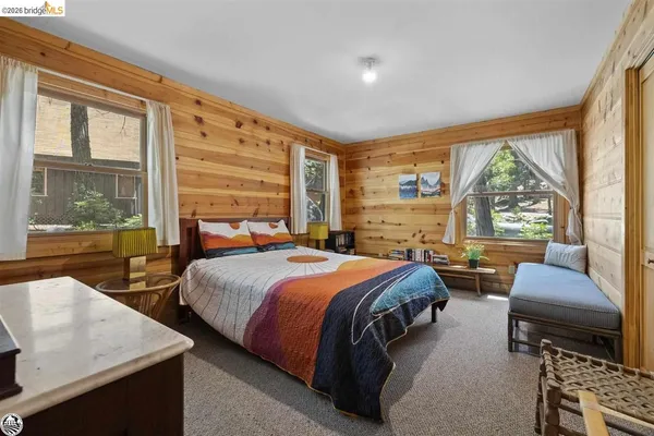 a bedroom with a bed and a couch next to a large window