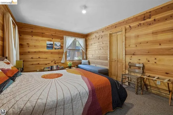 a bedroom with a bed next to a window
