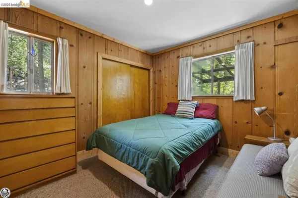 a bed sitting in a bedroom next to a window