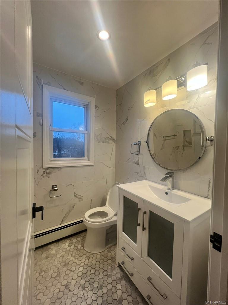 36 Roanoke Avenue, Unit 2 Rye Brook, NY 10573 - Photo 14 of 15 a spacious bathroom with a toilet sink and mirror