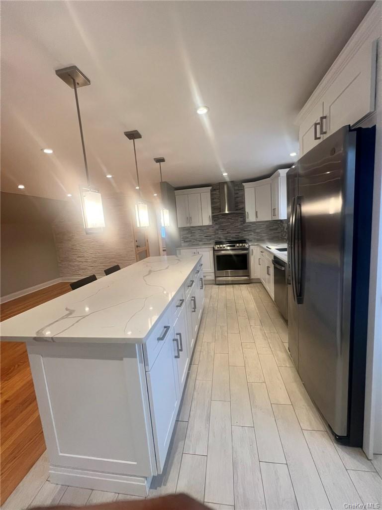 36 Roanoke Avenue, Unit 2 Rye Brook, NY 10573 - Photo 6 of 15 a view of a kitchen with kitchen island a counter top space a sink wooden floor and a refrigerator