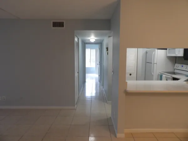 a room with a bed and a refrigerator