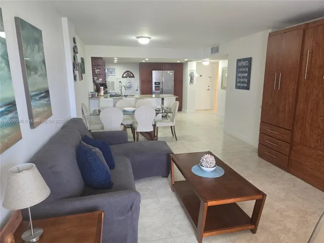 a living room with furniture kitchen view and a window