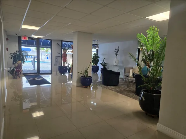 a living room with couches and kitchen view with wooden floor
