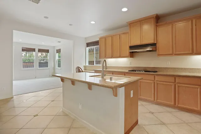 a kitchen with kitchen island granite countertop a sink stove and cabinets