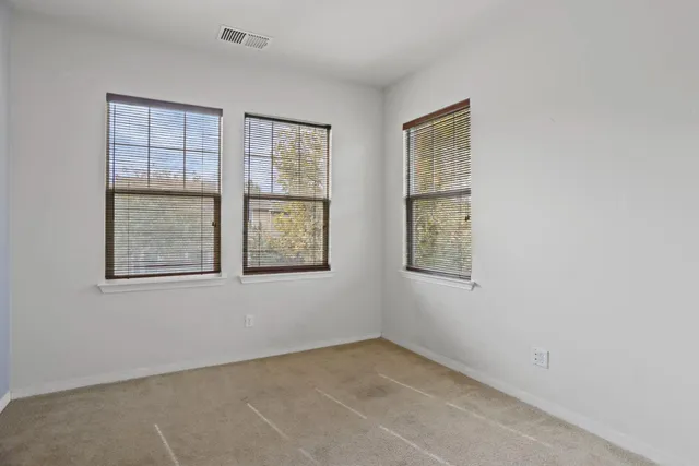 an empty room with windows and closet