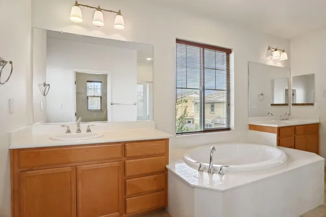 a bathroom with a tub sink and mirror