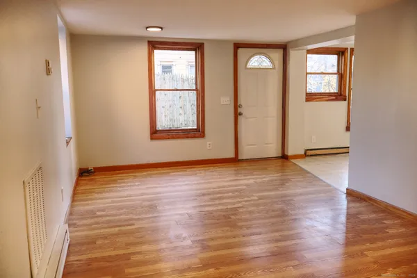 an empty room with wooden floor and windows