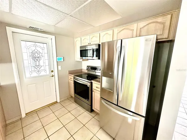 a large kitchen with a stove a refrigerator and a sink