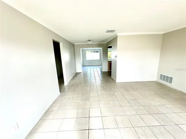 a view of a hallway with wooden floor and a living room