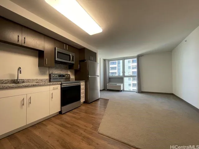 a large kitchen with granite countertop a stove a sink and a refrigerator
