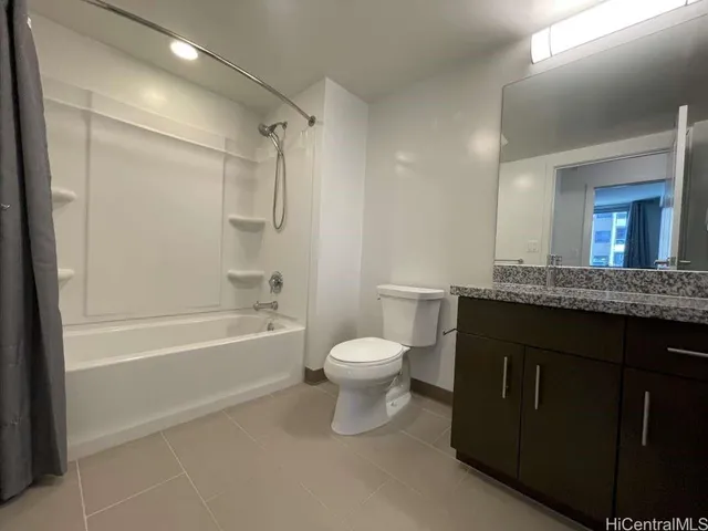 a bathroom with a granite countertop sink toilet a large mirror a bathtub and shower