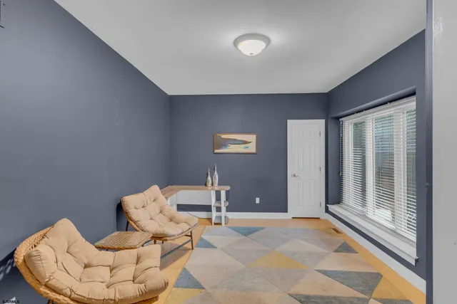 a bedroom with a bed and a window with a chair