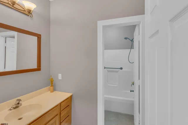 a spacious bathroom with a granite countertop tub sink and mirror