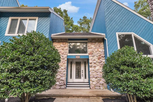 a front view of a house with plants