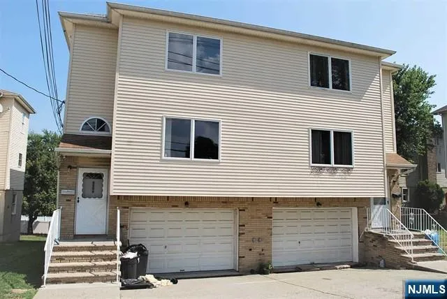 a view of house that has a car parked on road