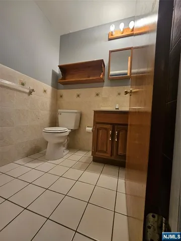 a view of a hallway with wooden floor and a bathroom
