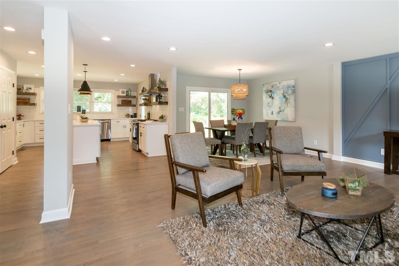 3804 Colgate Place Raleigh, NC 27609 - Photo 11 of 30 a living room with fireplace furniture and a dining table with wooden floor