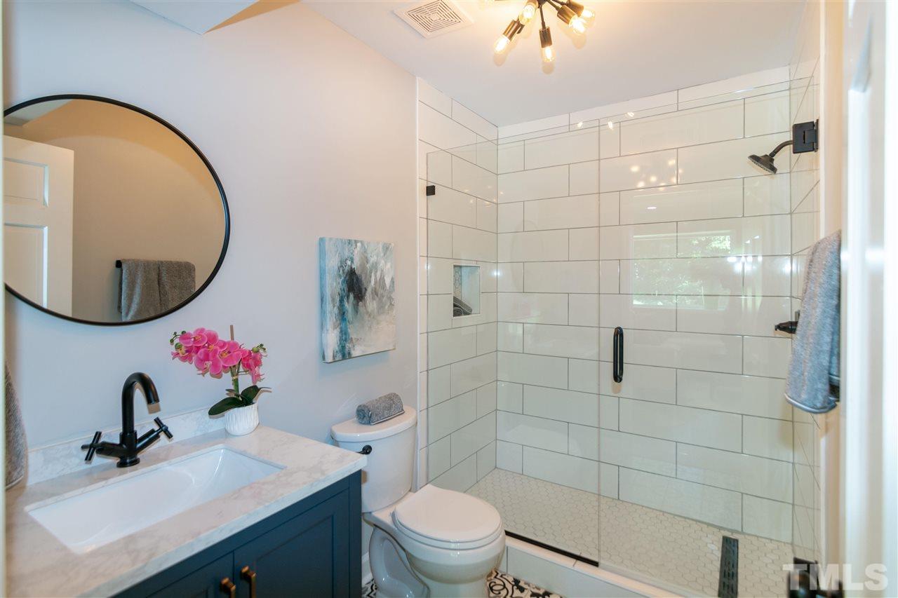 3804 Colgate Place Raleigh, NC 27609 - Photo 18 of 30 a bathroom with a sink mirror toilet and shower
