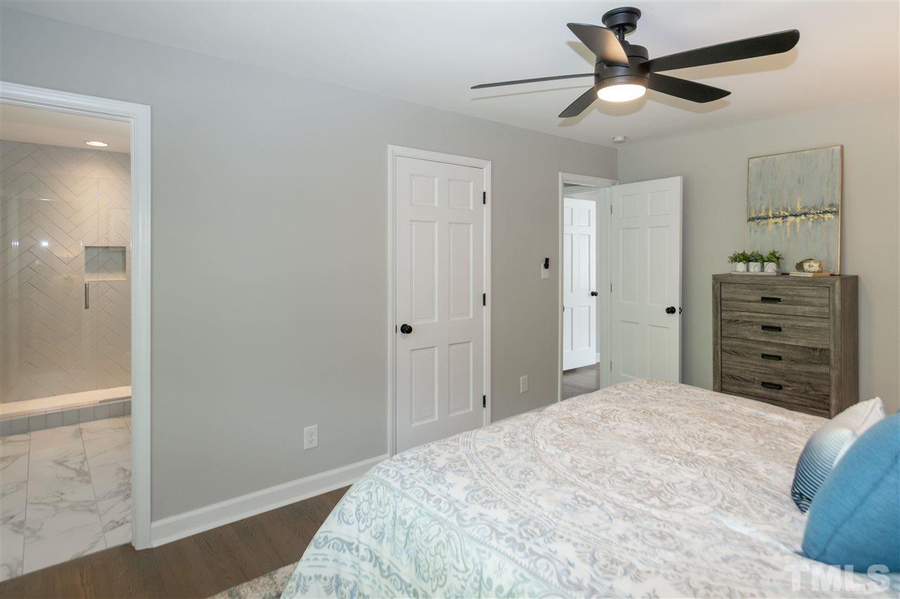 3804 Colgate Place Raleigh, NC 27609 - Photo 21 of 30 a bedroom with a bed and a chandelier fan