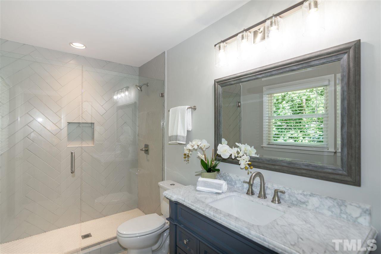 3804 Colgate Place Raleigh, NC 27609 - Photo 22 of 30 a bathroom with a granite countertop sink a toilet and shower