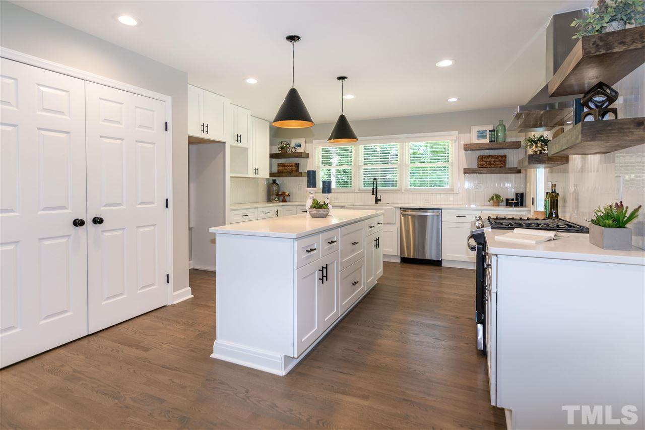 3804 Colgate Place Raleigh, NC 27609 - Photo 9 of 30 a kitchen with a sink stove cabinets and wooden floor