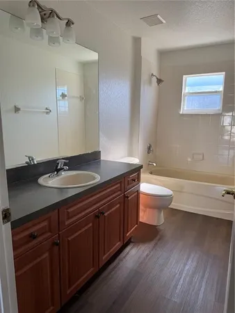a bathroom with a granite countertop toilet a sink and a bathtub
