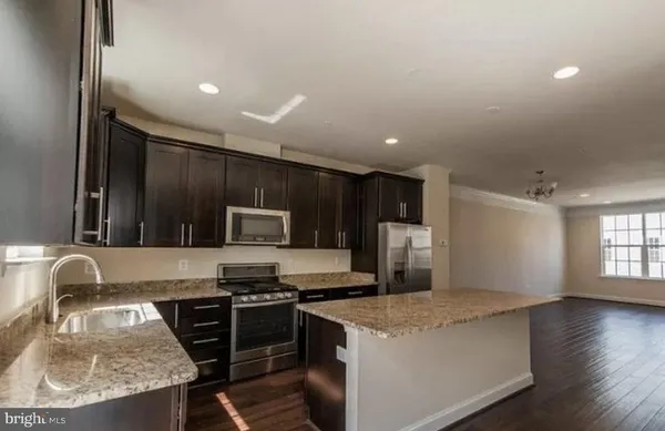 a kitchen with granite countertop a stove and a sink