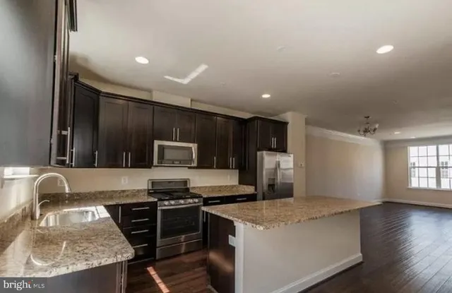 a kitchen with granite countertop a stove and a sink