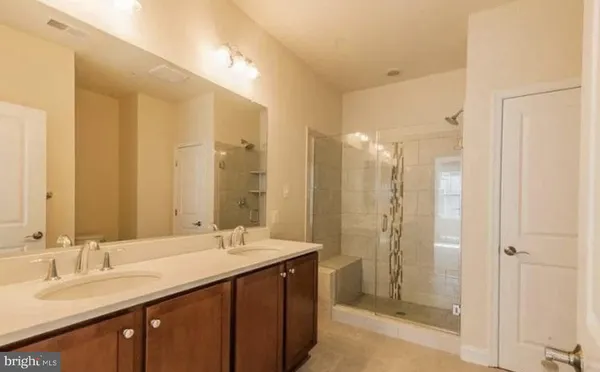 a bathroom with double vanity sinks and a shower