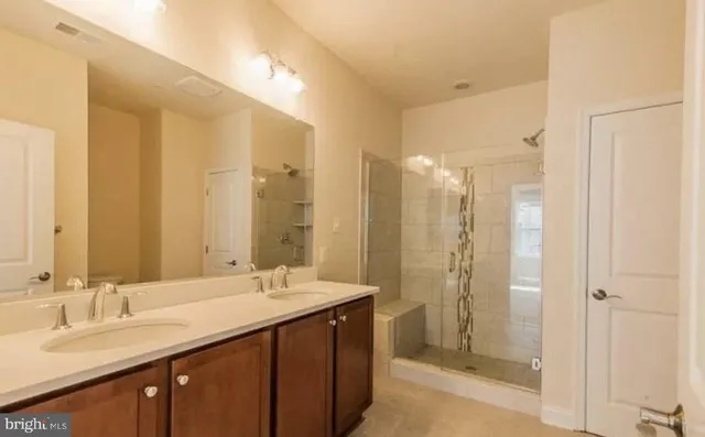 a bathroom with double vanity sinks and a shower