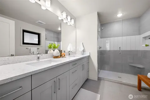 a bathroom with a sink a large mirror and a shower