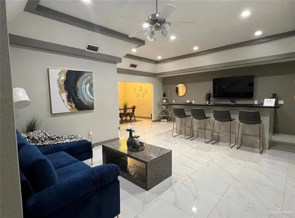 a living room with furniture a flat screen tv and kitchen view