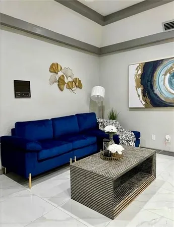 a living room with furniture and painting on the wall
