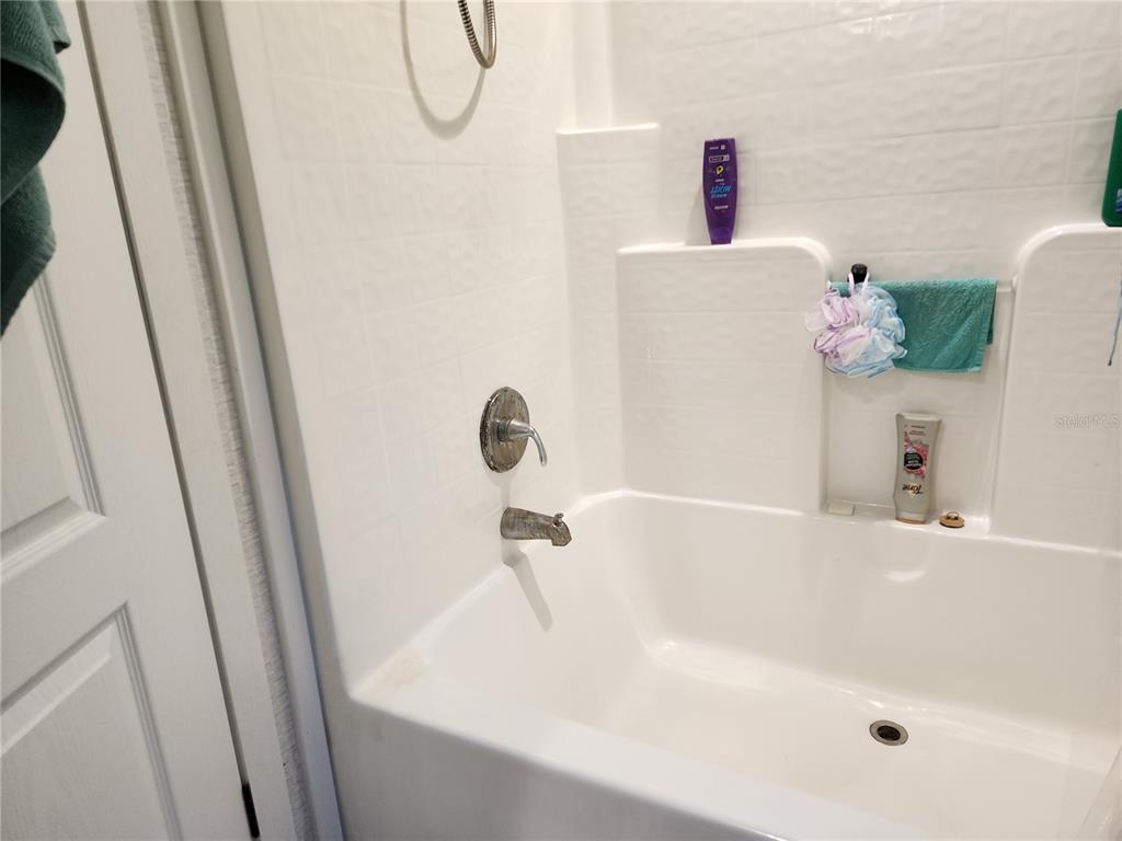 4150 South Spaniel Trail Inverness, FL 34450 - Photo 13 of 25 a bath tub sitting next to a white sink and a shower