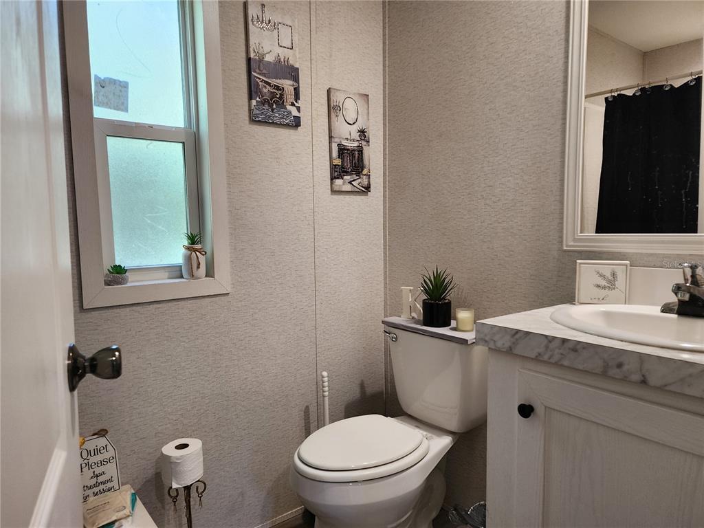 4150 South Spaniel Trail Inverness, FL 34450 - Photo 15 of 25 a bathroom with a granite countertop toilet sink and mirror