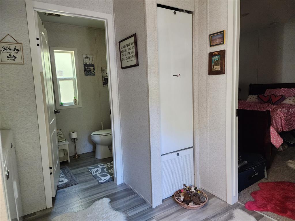 4150 South Spaniel Trail Inverness, FL 34450 - Photo 17 of 25 a view of a hallway with wooden floor and a bedroom