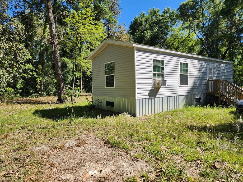 4150 South Spaniel Trail Inverness, FL 34450 - Photo 19 of 25 a front view of a house with a yard and potted plants