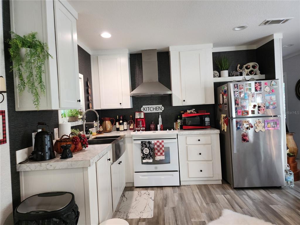 4150 South Spaniel Trail Inverness, FL 34450 - Photo 8 of 25 a kitchen with stainless steel appliances granite countertop a refrigerator a stove and a wooden floors