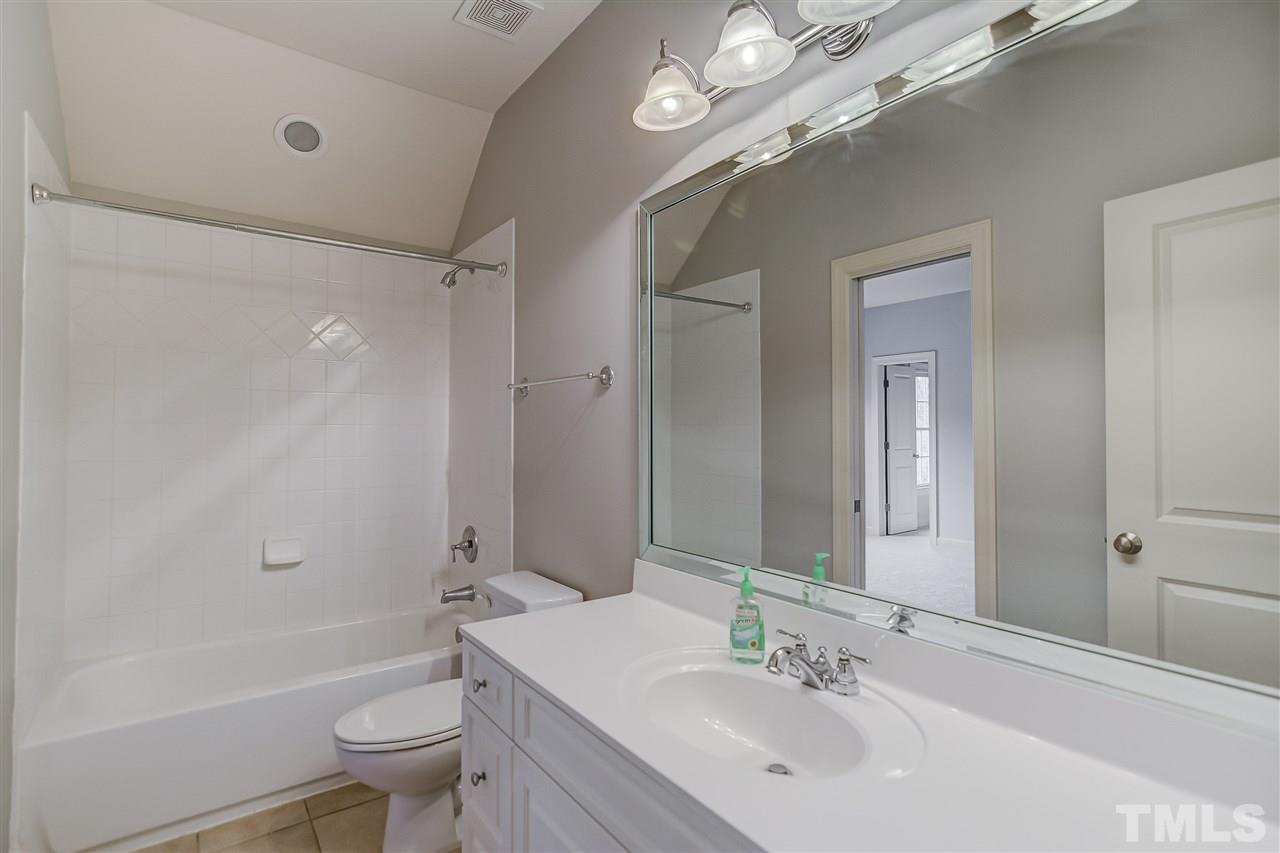 4213 Batiste Road Raleigh, NC 27613 - Photo 19 of 30 a bathroom with a bathtub shower sink vanity mirror and toilet