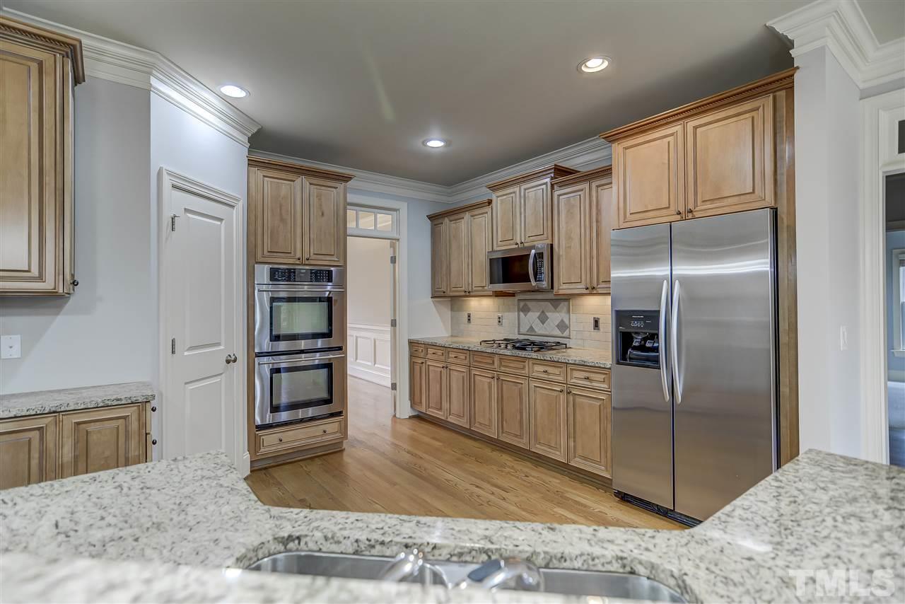 4213 Batiste Road Raleigh, NC 27613 - Photo 7 of 30 a kitchen with stainless steel appliances granite countertop a refrigerator a stove and a sink