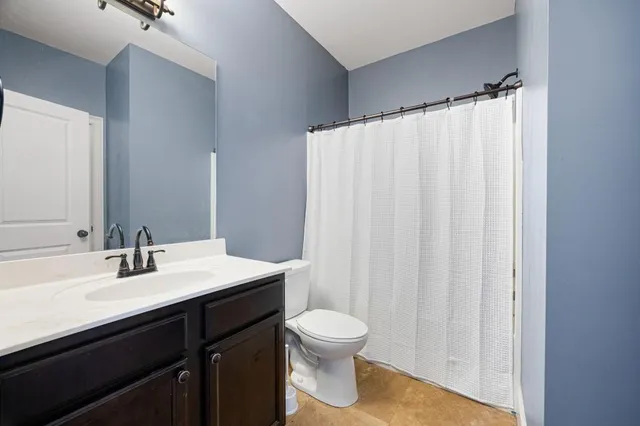 a bathroom with a sink a toilet and shower curtain