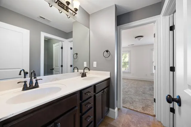 a bathroom with a double vanity sink a mirror and shower