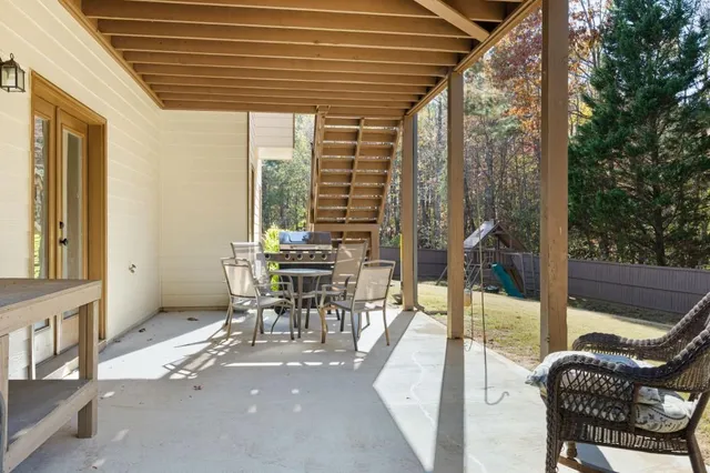 a view of a patio with table and chairs and floor to ceiling window