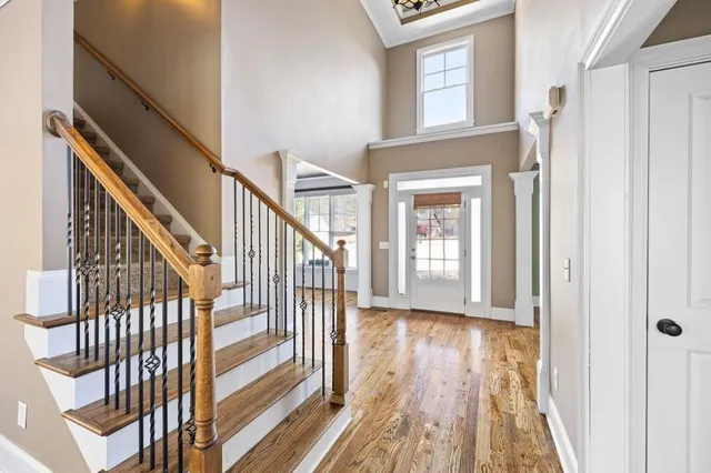 a view of a hallway with wooden floor and staircase