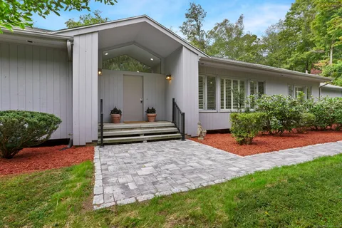 a backyard of a house with plants and outdoor seating